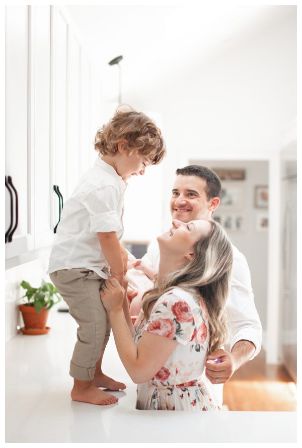 Happy parents with son in the kitchen for lifestyle family newborn session