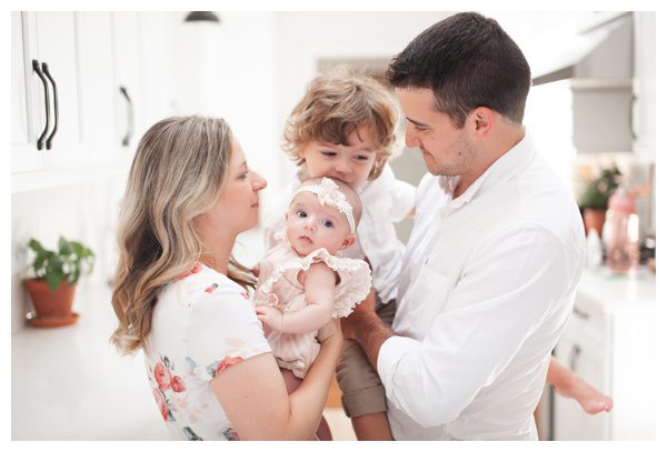 Adorable family portrait in bright, white sunny kitchen for life style newborn portraits in Fairfield County, CT