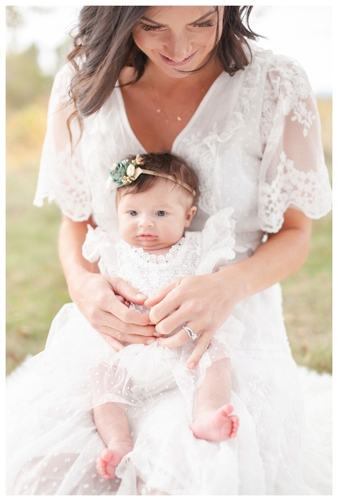 Beautiful mom holding baby in white dress