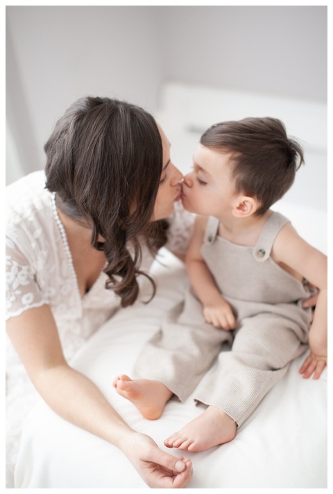 Mother kissing son during maternity photoshoot