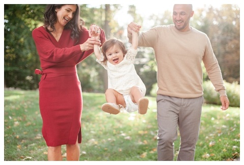 Mom and dad swinging toddler