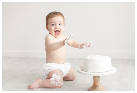 Happy baby during first birthday cake smash photos
