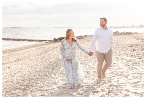Beautiful maternity beach photo - couple walking on the beach holding hands