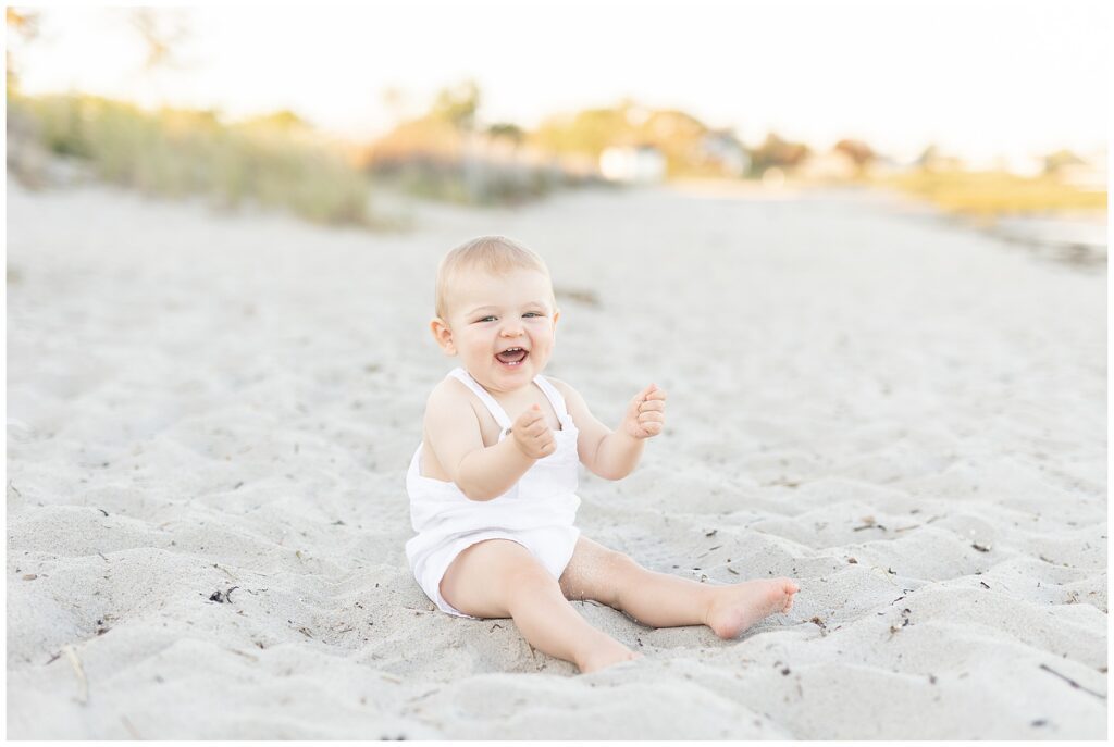 Happy baby photos on the beach in Fairfield County CT. The most adorable one year old boy getting his picture taken by Forty Seven Moments Photography on the beach.