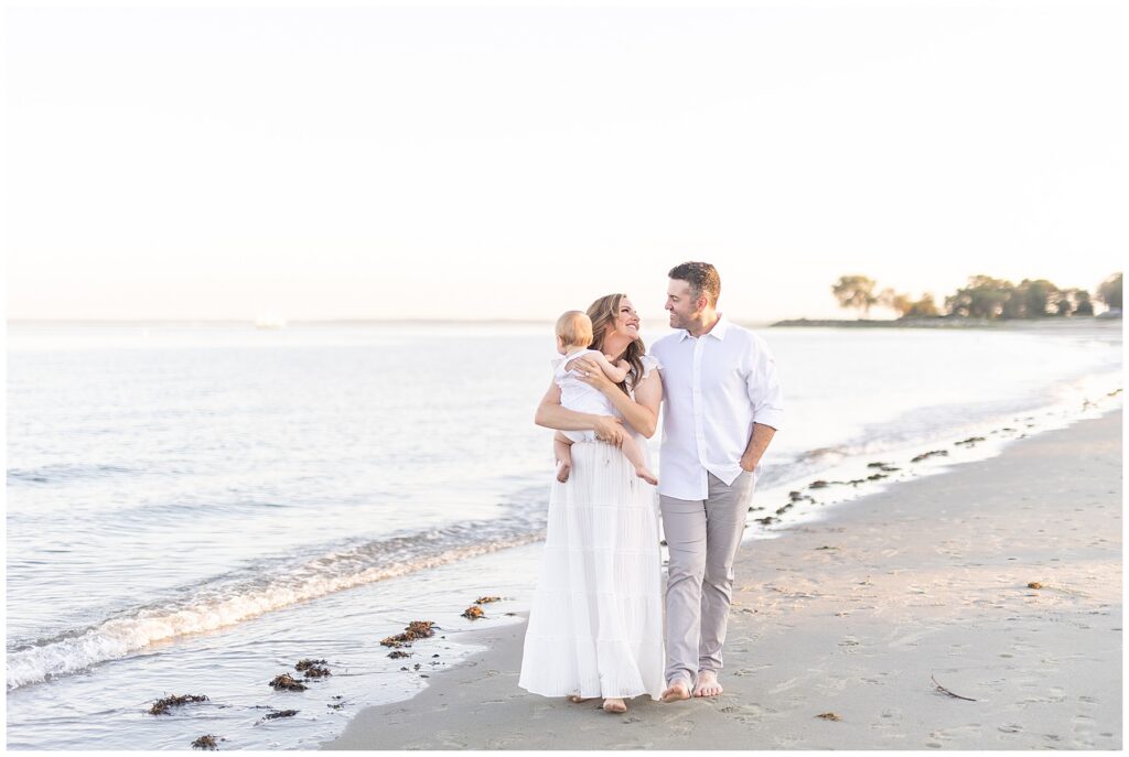 Gorgeous, family portraits on the beach at Tod's Point in Greenwich CT. A Fairfield County Photographer photographs a family of three on the beach providing candid moments, guided posing that feels natural.